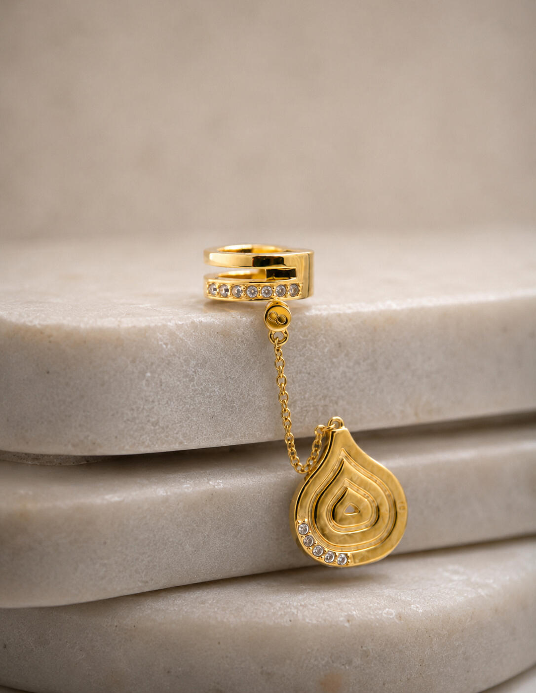 a silver hair cuff and pendant, screwed in together on tiles