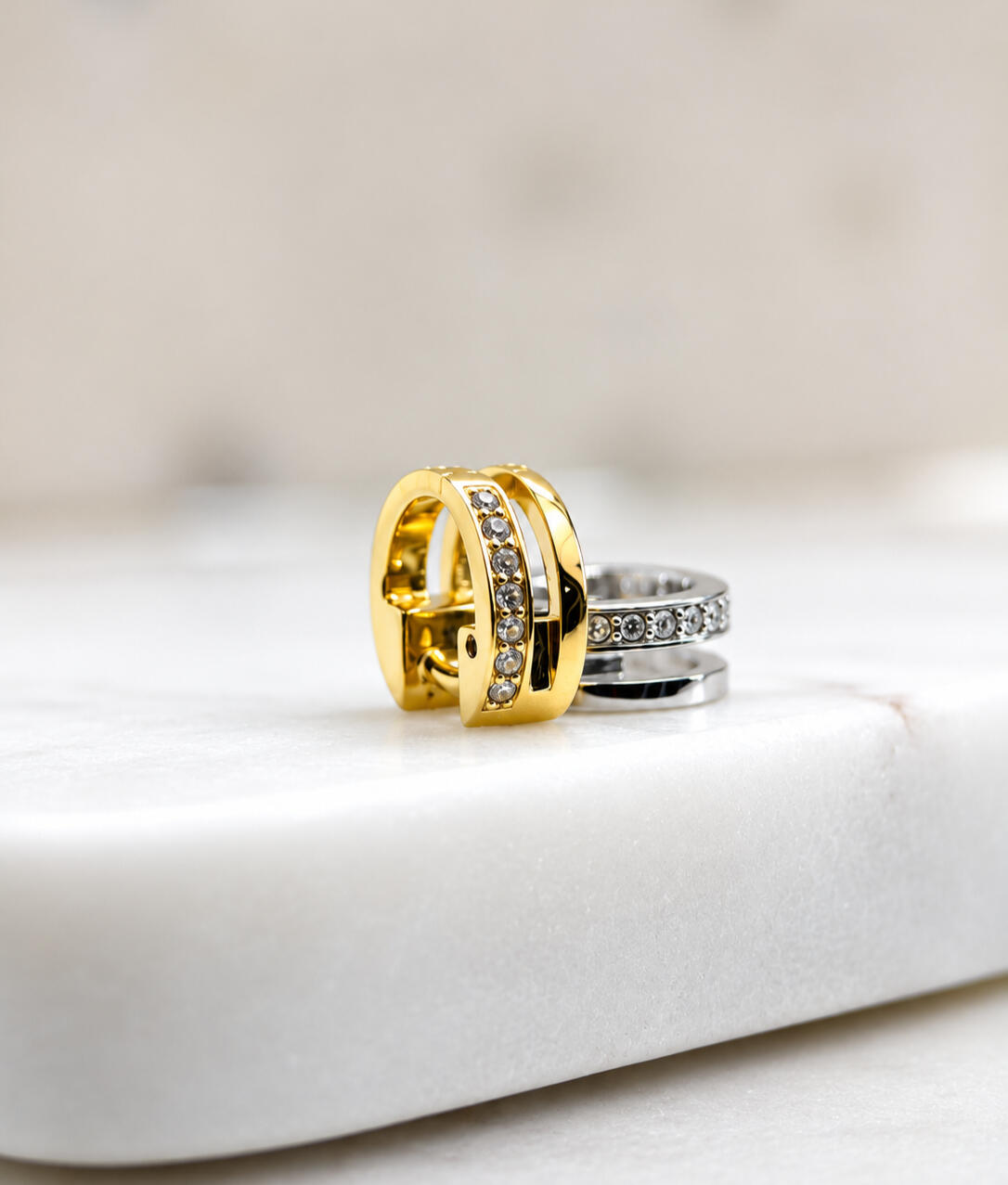 2 hair cuffs, gold and silver, on tiles
