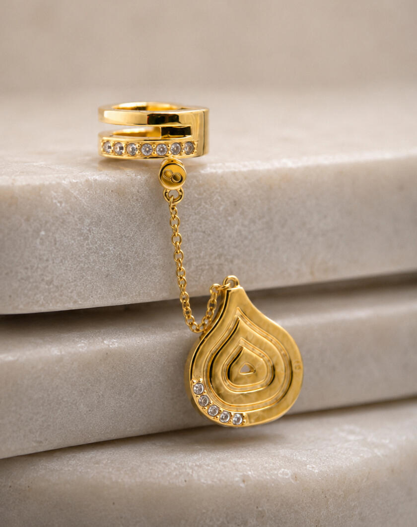 Gold hair cuff and pendant on tiles