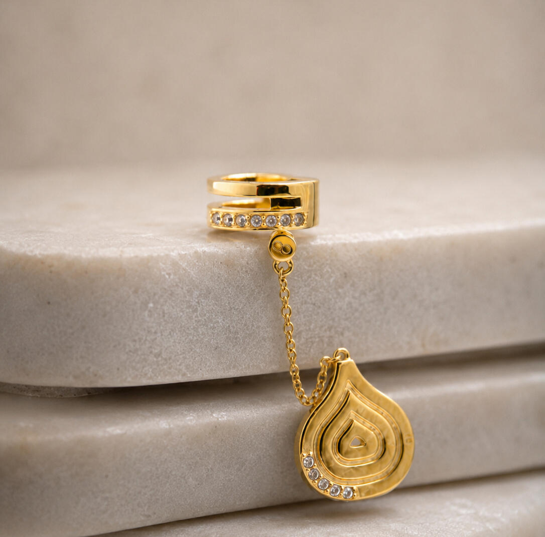 Gold hair cuff and pendant on tiles