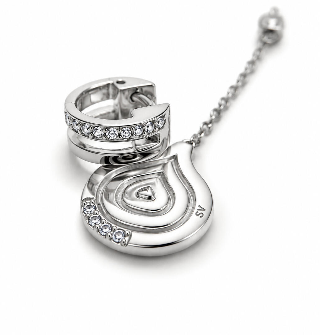 a silver hair cuff and pendant on white background