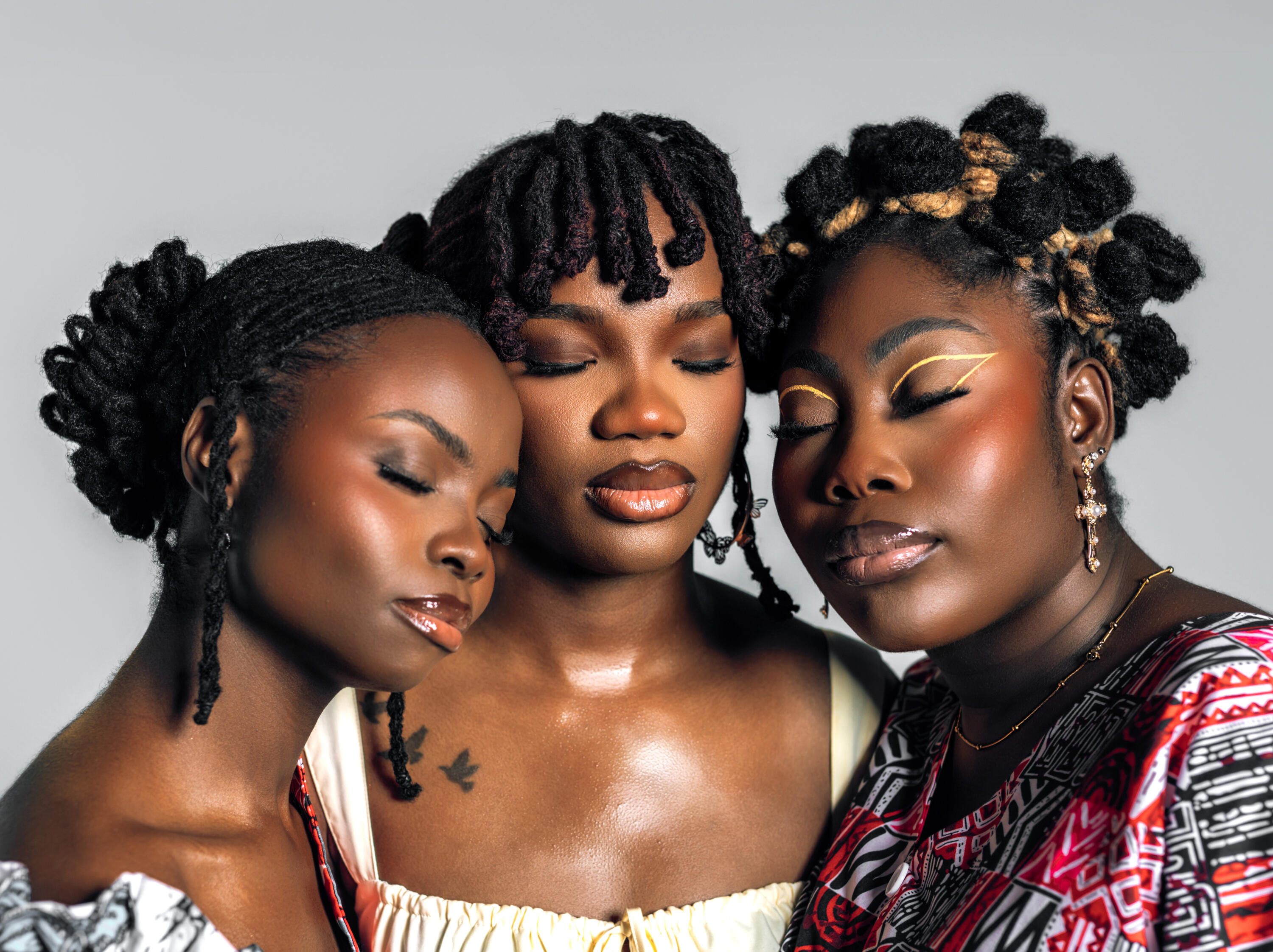 Photo of 3 women with locs, holding each other